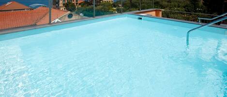 Alberca al aire libre por temporada y sombrillas en la alberca