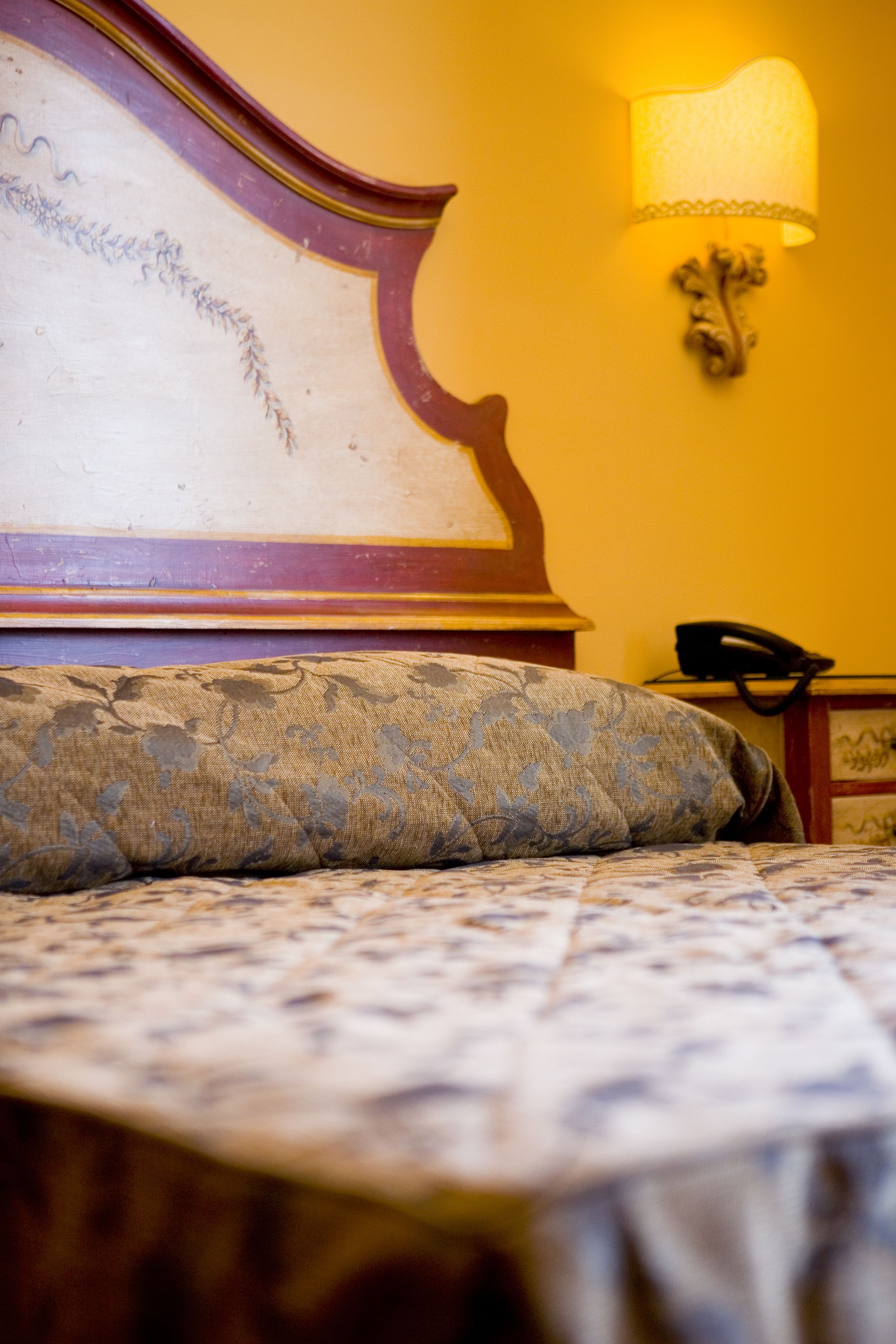 A bed with a patterned bedspread and a headboard with a decorative design.