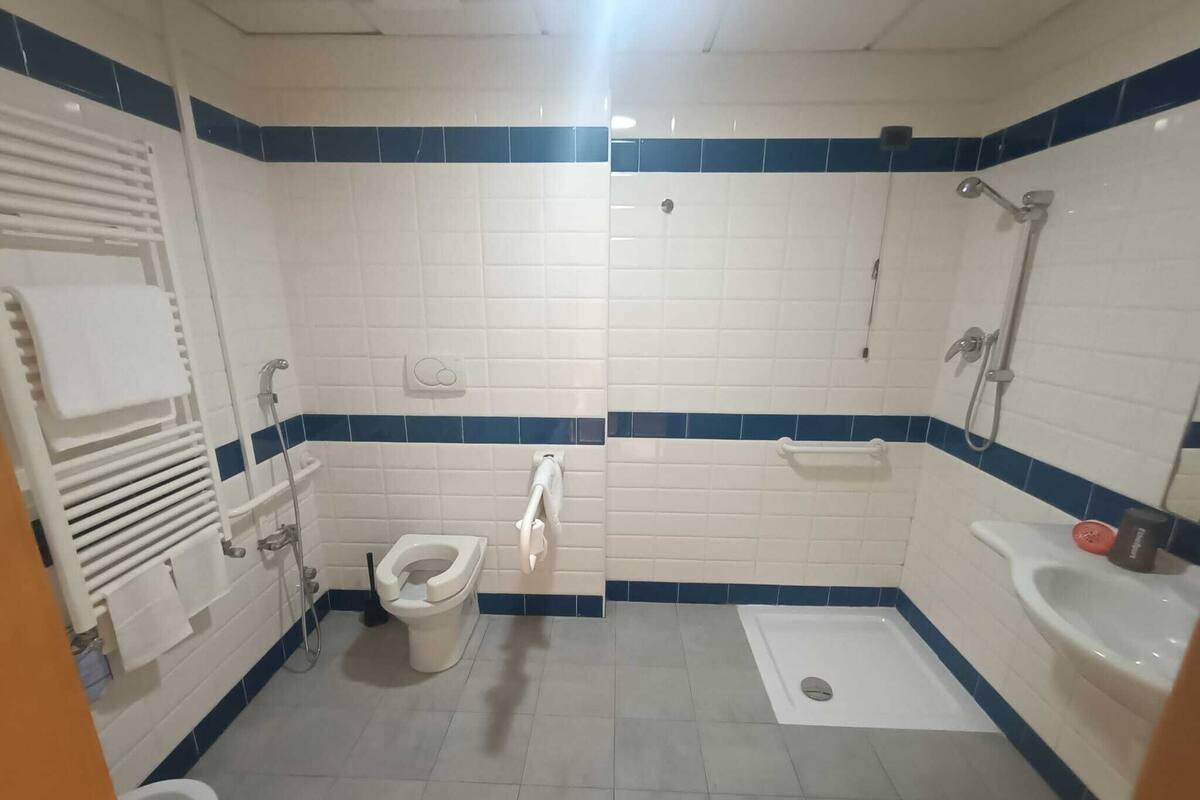 A bathroom with a toilet, bidet, sink, and shower.