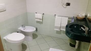 Un baño con inodoro, bidé y lavamanos.