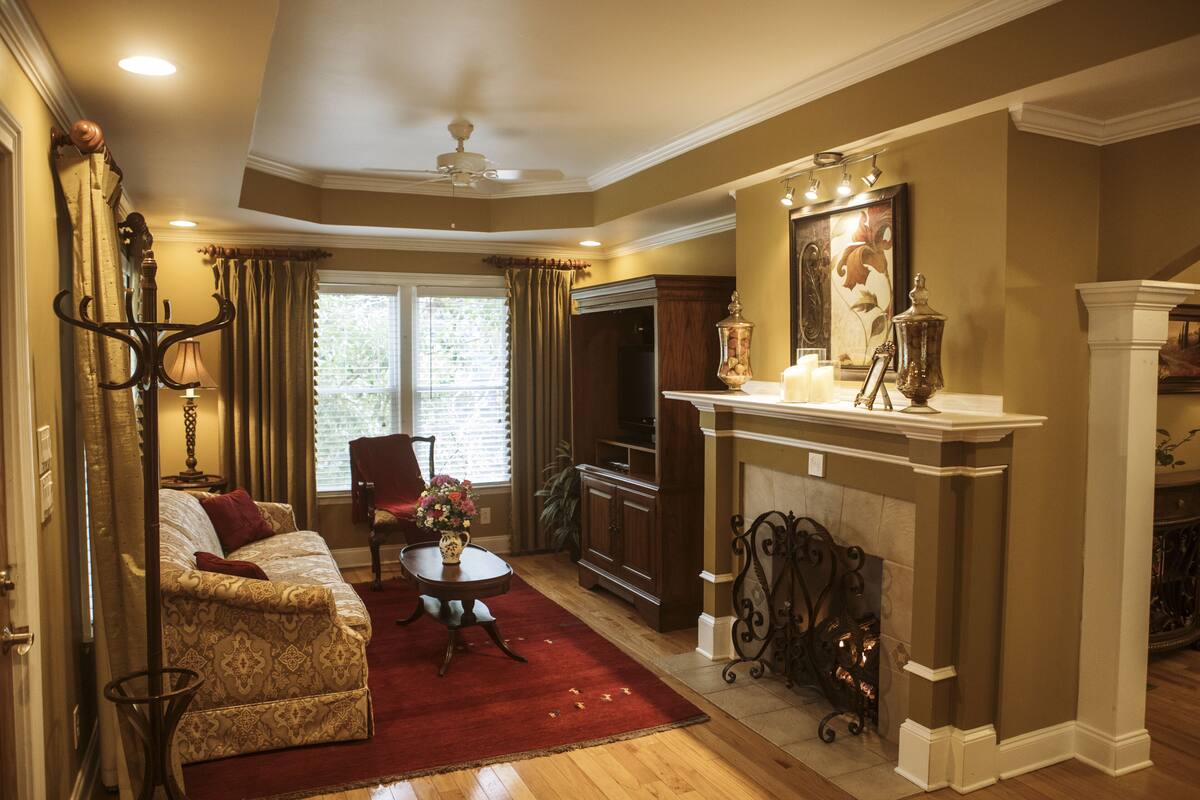 A living room with a sofa, a coffee table, a fireplace, and a television.