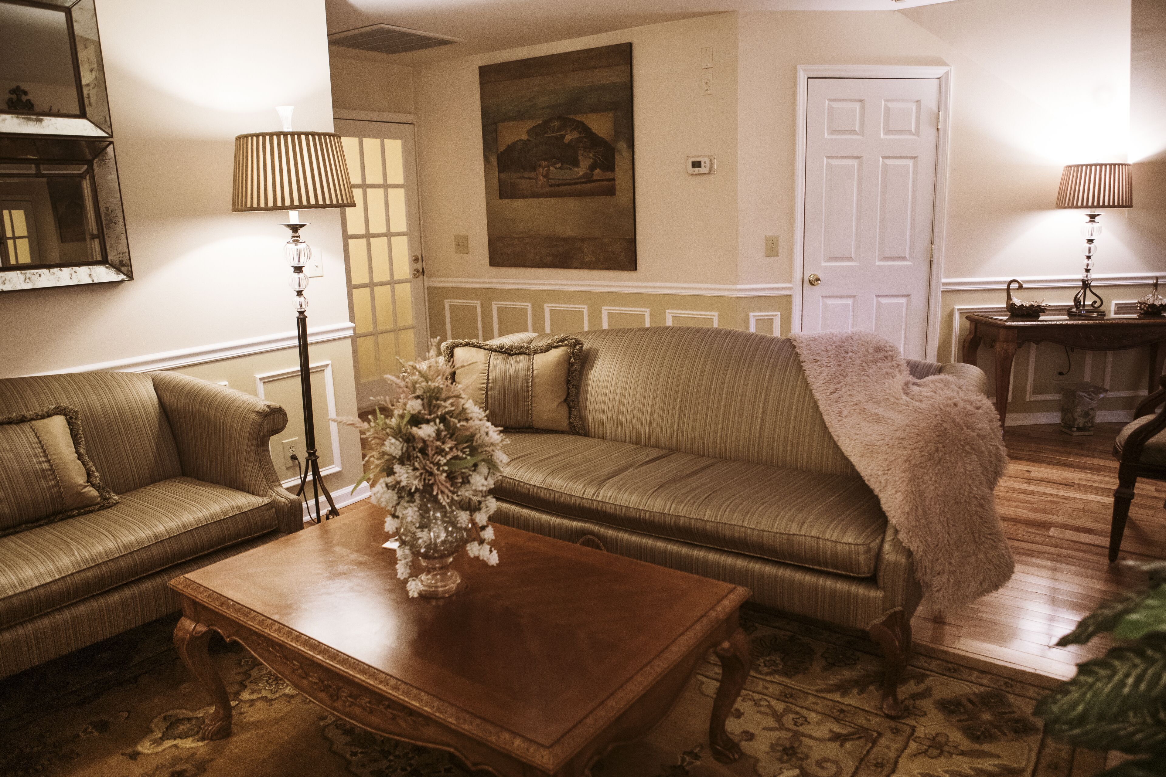 A cozy living room with a sofa, a coffee table, and two lamps.