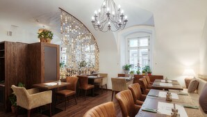 Un restaurant avec des meubles en bois, un lustre et une grande fenêtre.