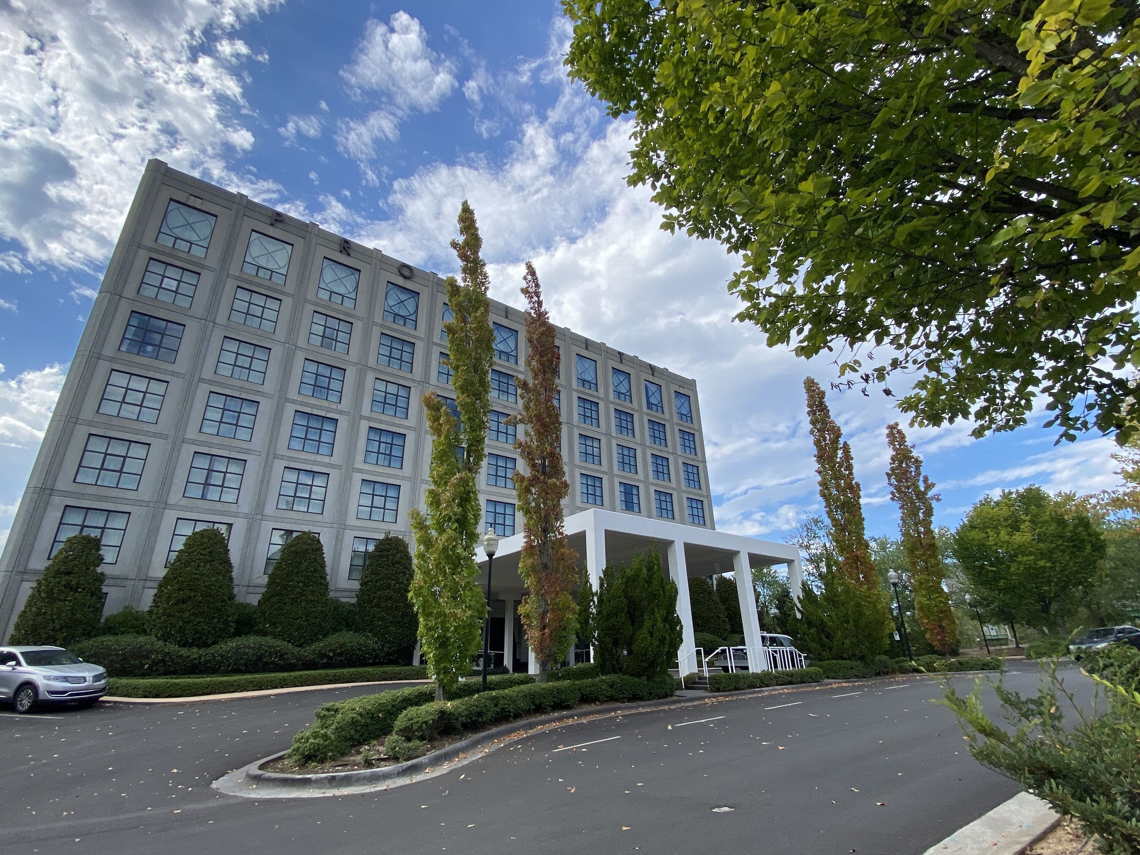 A modern building with a symmetrical facade, large windows, and a covered entrance area.