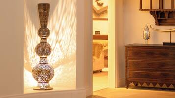 A room with a decorative floor lamp, a wooden dresser, and a patterned rug.
