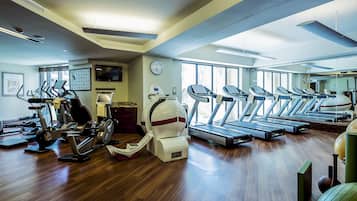 A gym with treadmills, stationary bikes, and elliptical machines.