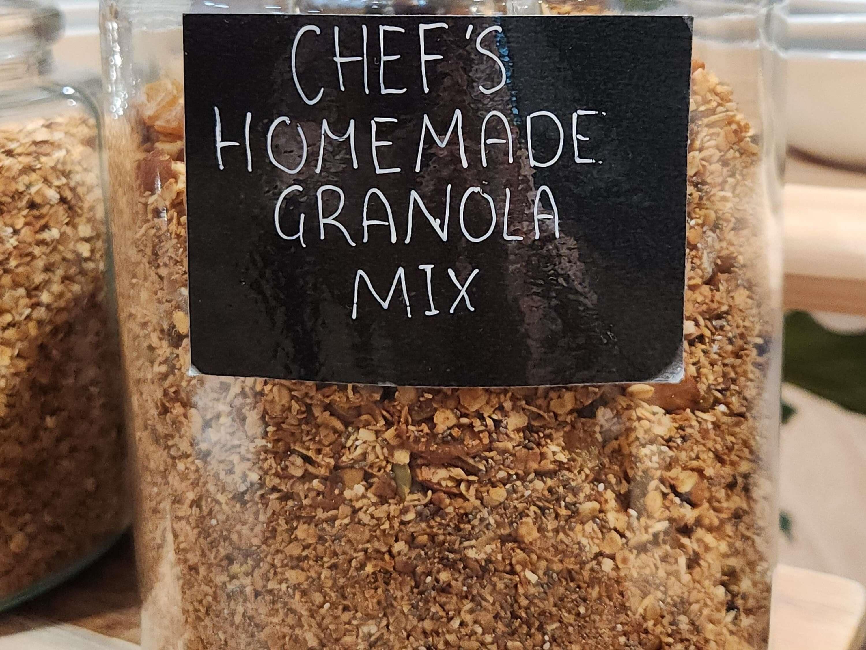 A container labeled 'CHEF'S HOMEMADE GRANOLA MIX' filled with granola.