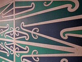 Primer plano de una pared de madera con patrones estilizados y elaborados.