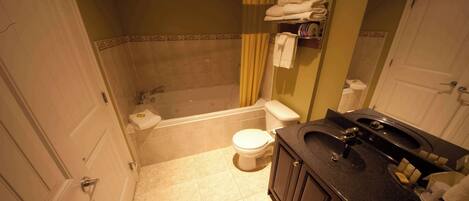 Un baño con bañera, inodoro y lavamanos.
