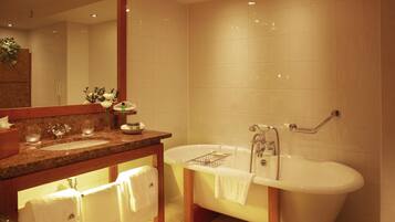 Une salle de bain moderne avec une baignoire sur pieds, un meuble-lavabo avec un miroir et un évier.