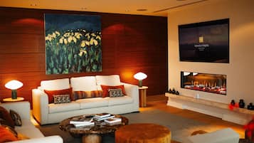 Una sala de estar moderna con un sofá, una mesa de centro y un televisor de pantalla plana montado en la pared.