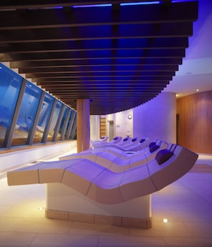Relax in our serene wellness area, featuring a row of massage chairs and large windows.