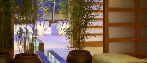 A traditional Japanese-style room with tatami flooring, a low wooden table, and a bamboo plant in the foreground.