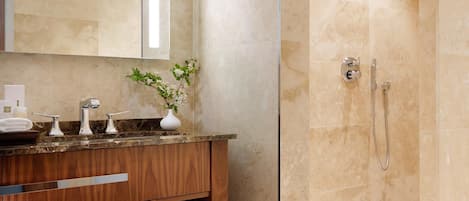 A modern bathroom with a marble vanity, a large mirror, a shower with a glass door, and a bathtub.
