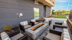 An outdoor seating area with wicker furniture and a central fire feature. - Fairfield Inn & Suites by Marriott Knoxville Clinton (Andersonville)