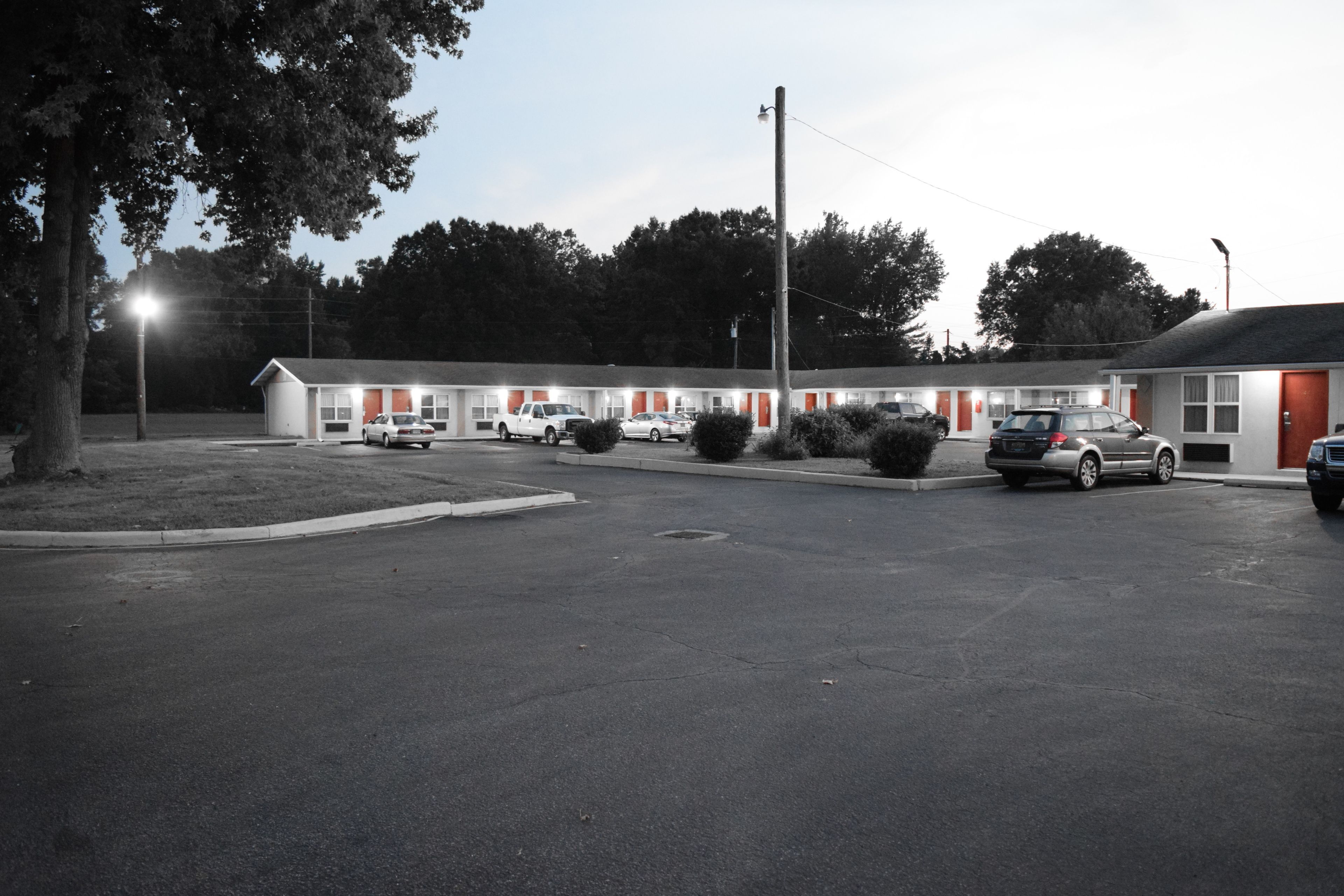 Un motel doté de plusieurs chambres, d’un parking et de quelques voitures garées devant.