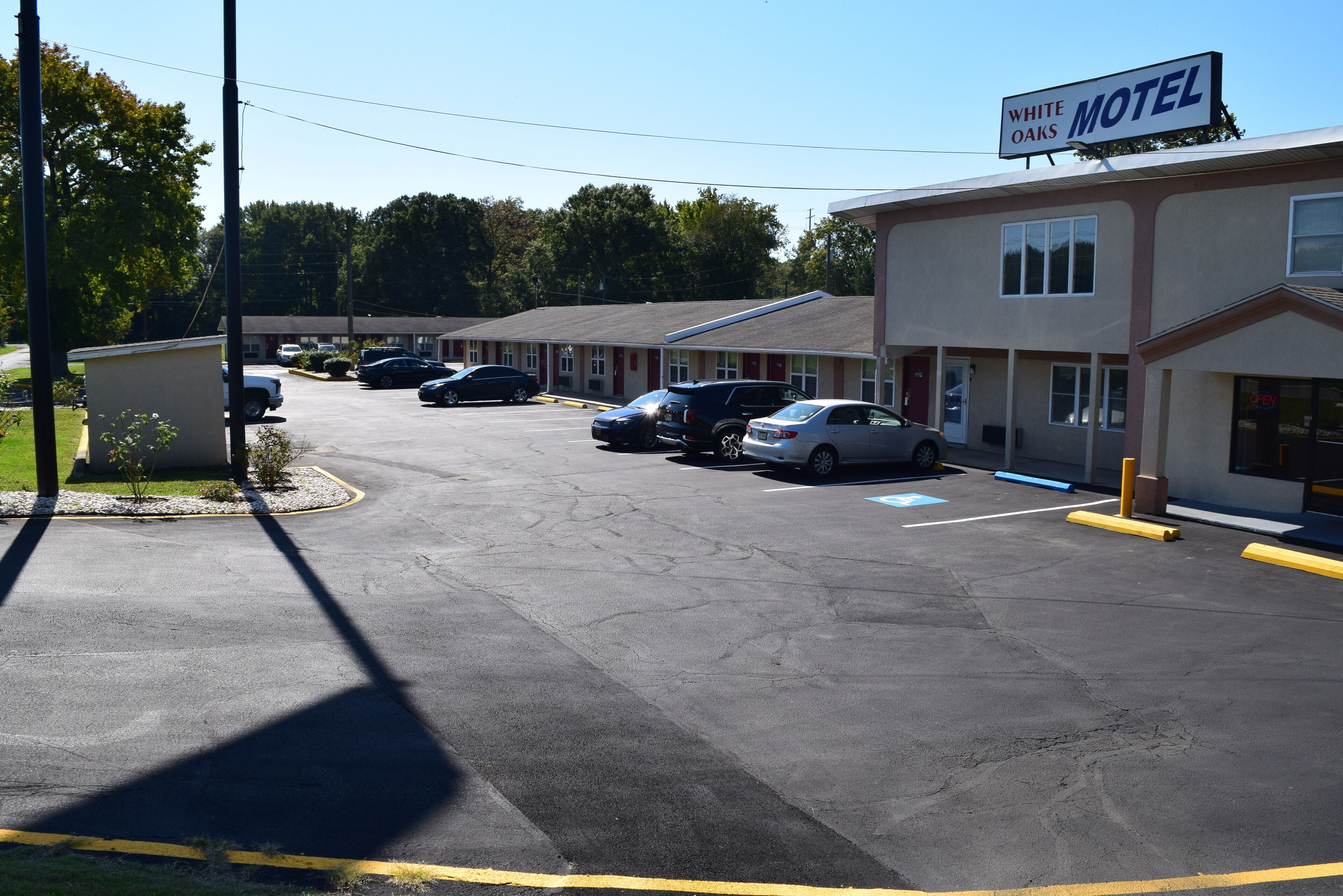 A motel with multiple parking spaces and a sign indicating the name 'White Oaks Motel'.