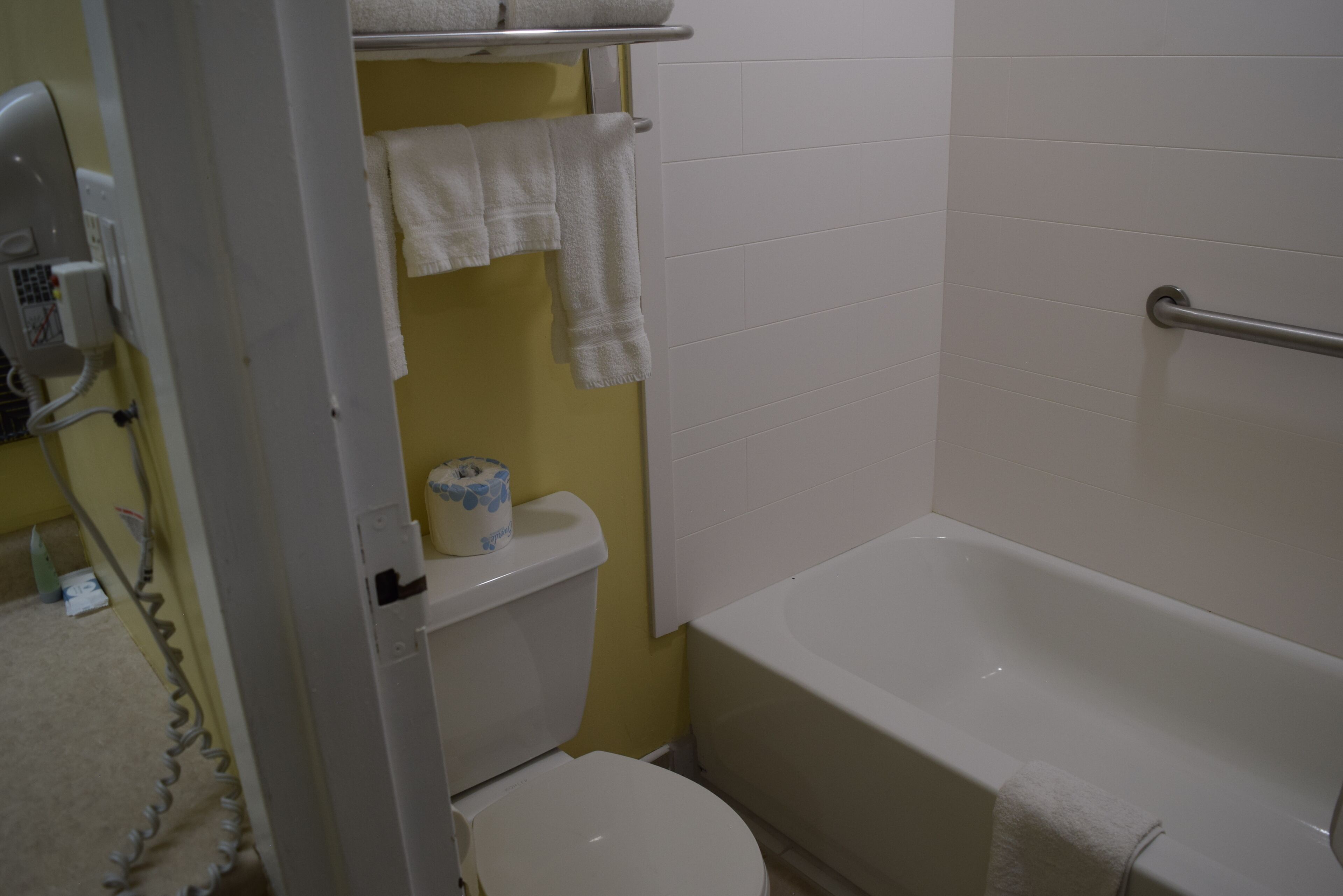 Une salle de bain équipée de toilettes, d’une baignoire et d’un porte-serviettes.