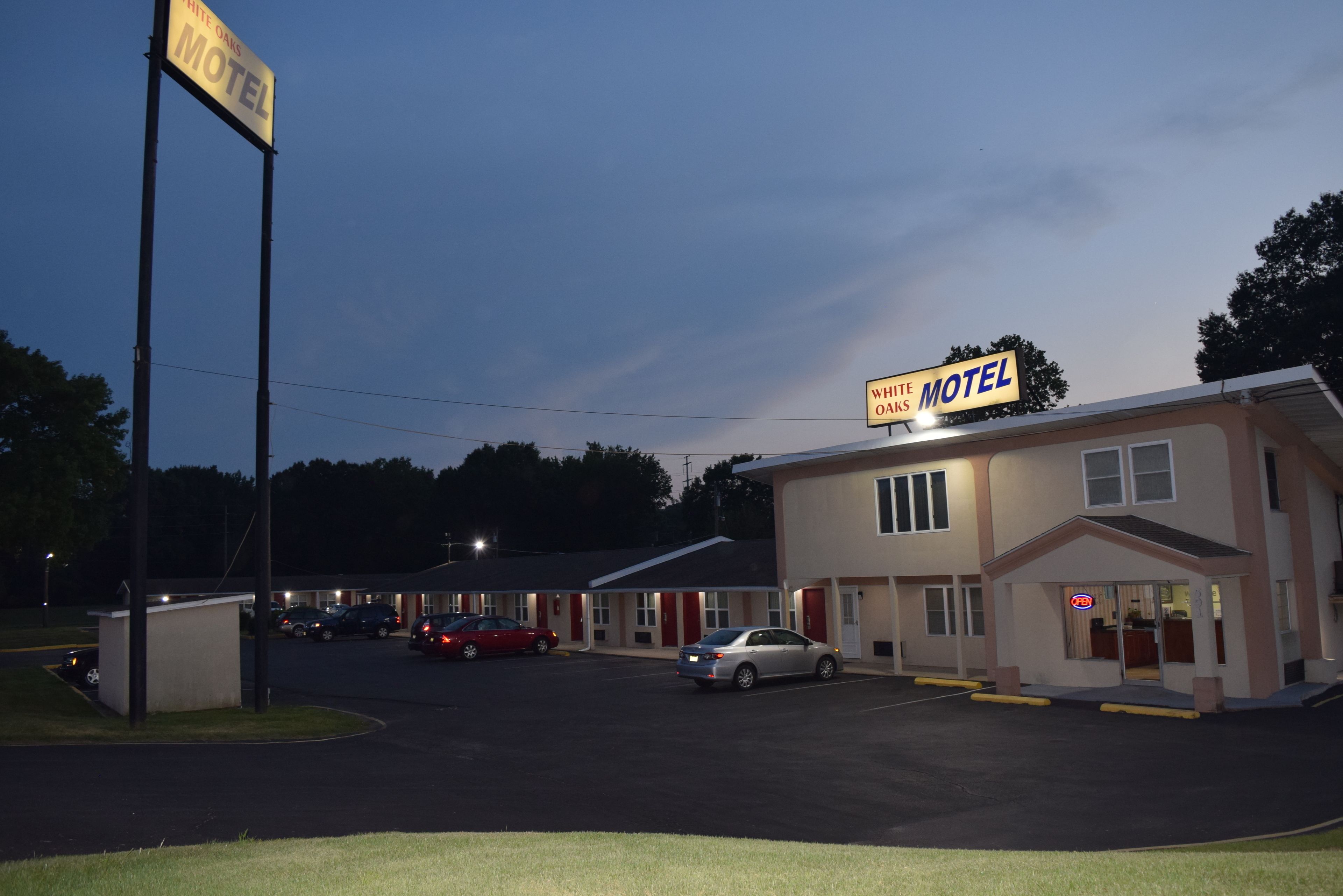 Um motel com uma placa que diz 'White Oaks Motel' e uma placa menor para 'White Oaks'.