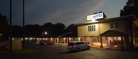 Un motel con un letrero que dice "WHITE MOTEL OAKS" de noche.