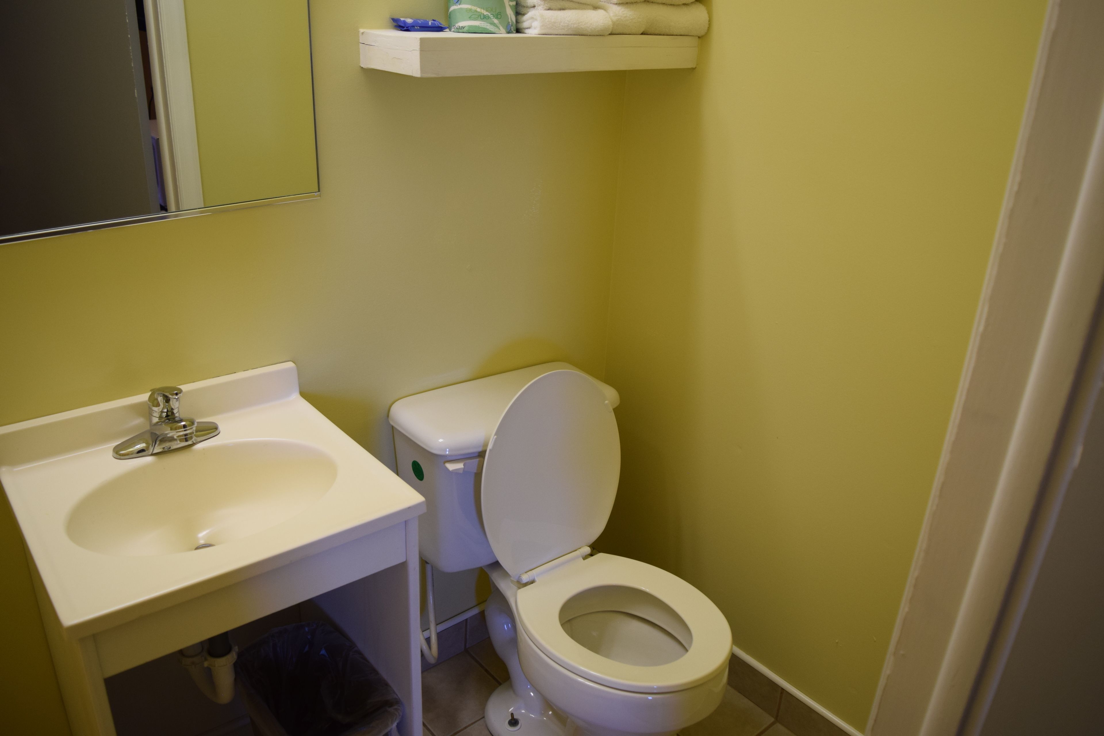 Ein Badezimmer mit Waschbecken, Toilette und Spiegel.