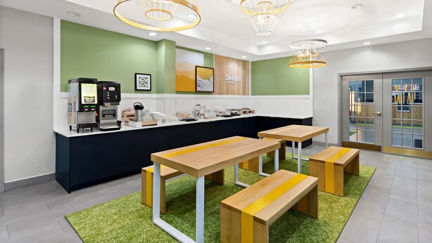A modern cafe with a counter, seating area, and decorative lighting. - Spark by Hilton Panama City Beach (Panama City Beach)