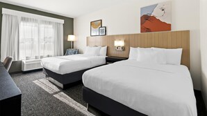 A hotel room with two beds, a desk, and a large window with curtains. - Spark by Hilton Panama City Beach (Panama City Beach)