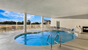 An indoor swimming pool with a clear view of the sky and surrounding buildings. - Spark by Hilton Panama City Beach (Panama City Beach)