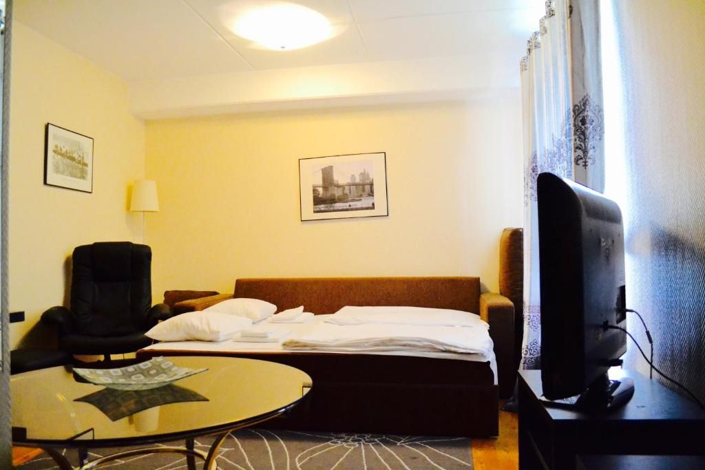 Una habitación de hotel con una cama, una silla, un escritorio con computadora y televisión.