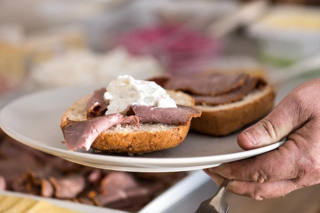 Una persona sosté un plat amb dos entrepans oberts.