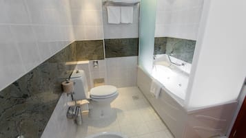 A bathroom with a toilet, bidet, sink, and bathtub.