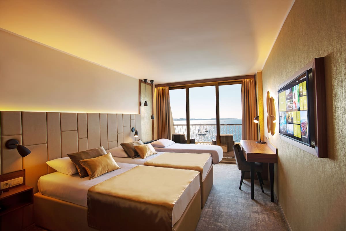 Deluxe Triple room, 1 Bedroom sea view | Minibar, safe på rommet, skrivebord og blendingsgardiner