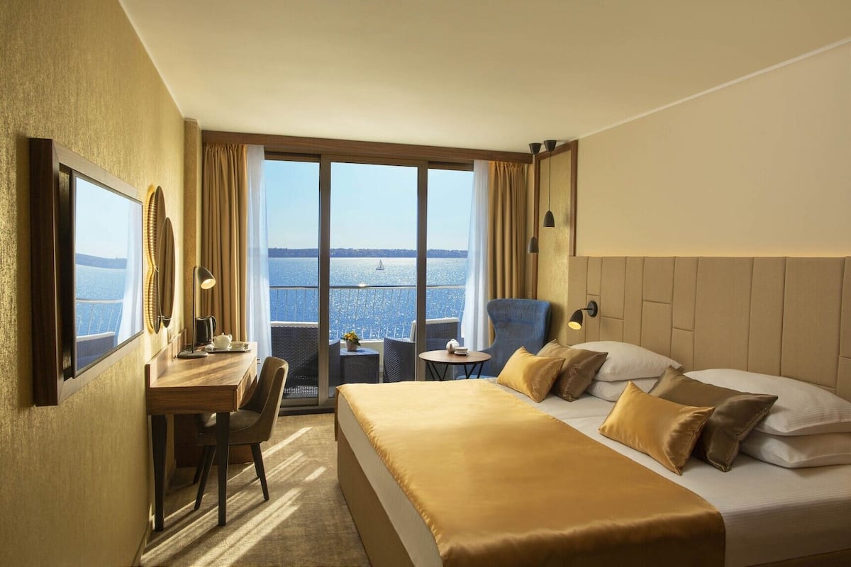 Deluxe Quadruple Room, 1 Bedroom | Minibar, caja fuerte, escritorio y cortinas opacas