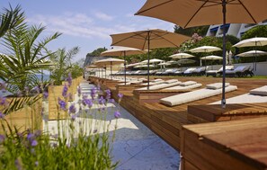 A poolside area with sun loungers and umbrellas, wooden deck, and a view of the sea. - Grand Hotel Bernardin - Sava Hotels & Resorts (Piran)