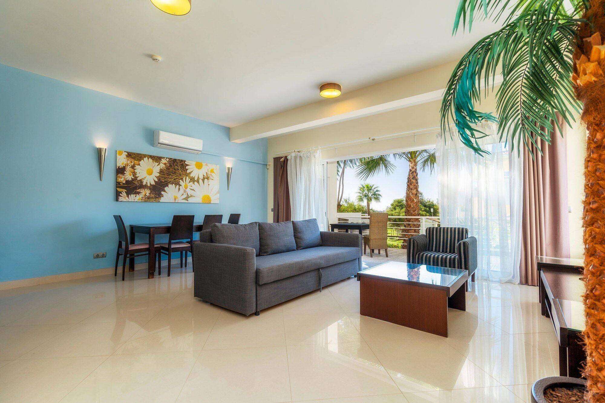 A modern living room with a sofa, coffee table, and dining area.