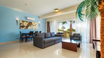 A modern living room with a sofa, coffee table, and dining area.