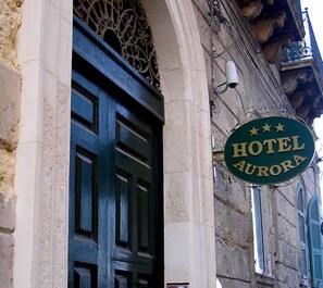A hotel sign with "HOTEL AURORA" and three stars. - Hotel Aurora (Syracuse)
