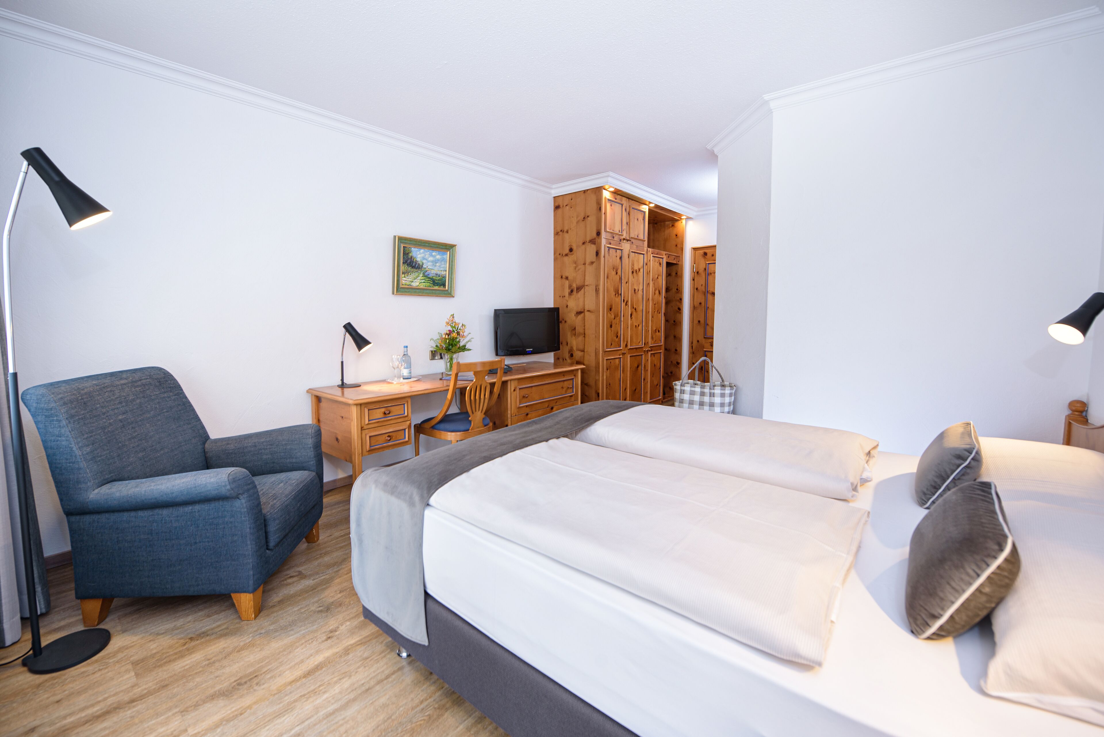 A bedroom with a bed, a desk, a chair, and a wardrobe.