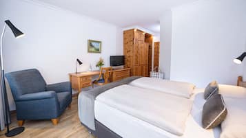 A bedroom with a bed, a desk, a chair, and a wardrobe.