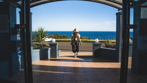 A person walking through an arched entrance with a view of the ocean. - Seafront Hotel Kangaroo Island (Penneshaw)