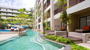A swimming pool with clear water, surrounded by greenery and lounge areas. - Deevana Plaza Phuket (Patong)