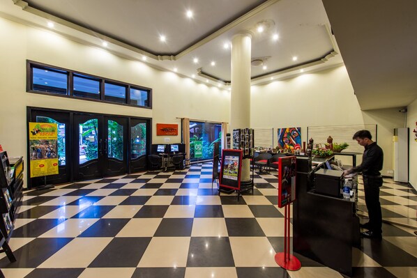 A lobby with a checkered floor, a reception desk, and a large pillar. - JK Resident (Siem Reap)