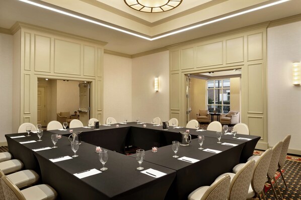 A conference room with a long table, chairs, and a chandelier.