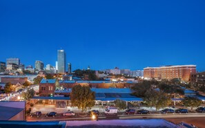 A cityscape at dusk with a prominent BB&T building, a parking lot with cars, and a hotel with a blue roof.