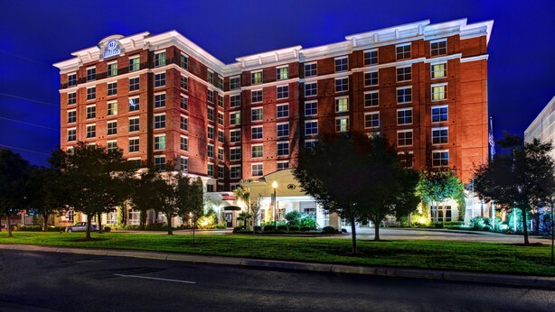 A multi-story hotel with a prominent Hilton sign, featuring a brick facade and multiple windows. - Hilton Columbia Center (Columbia)