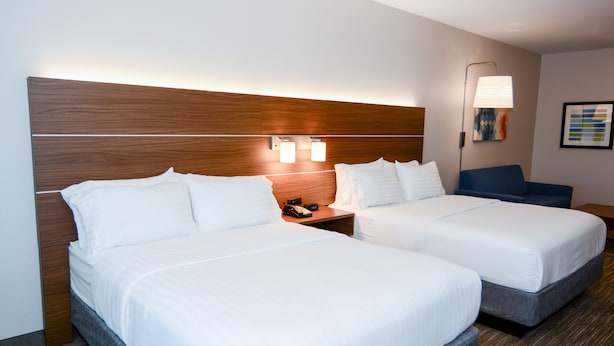 A hotel room with two beds, a nightstand, a lamp, and a framed picture on the wall. - Holiday Inn Express & Suites New Boston by IHG (New Boston)
