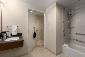 Une salle de bain équipée d’un lavabo, d’un miroir, d’un porte-serviettes, d’une douche et de toilettes.
