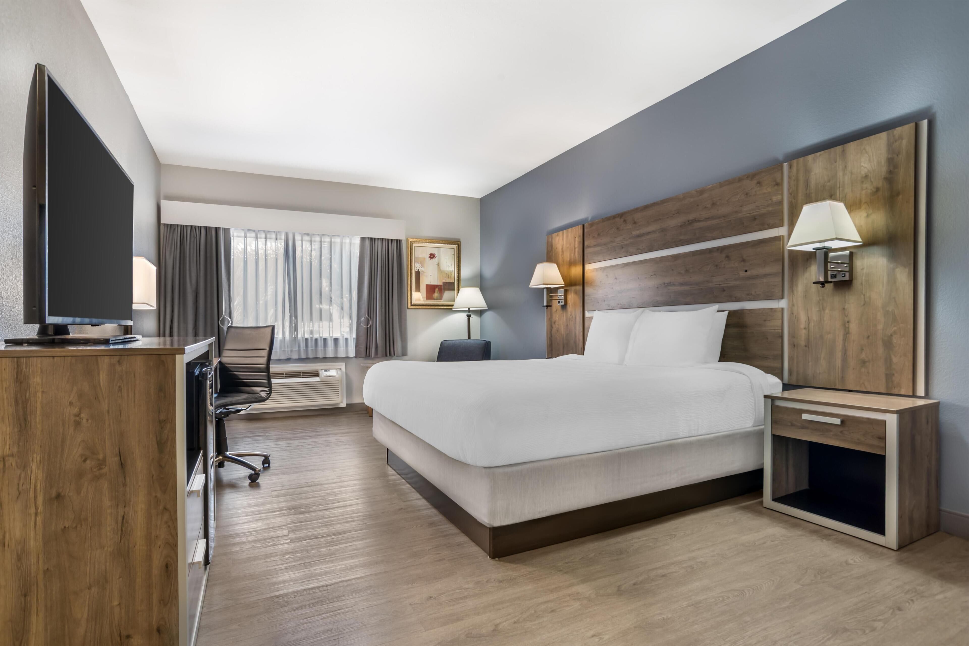 Premium bedding, desk, laptop workspace, blackout drapes