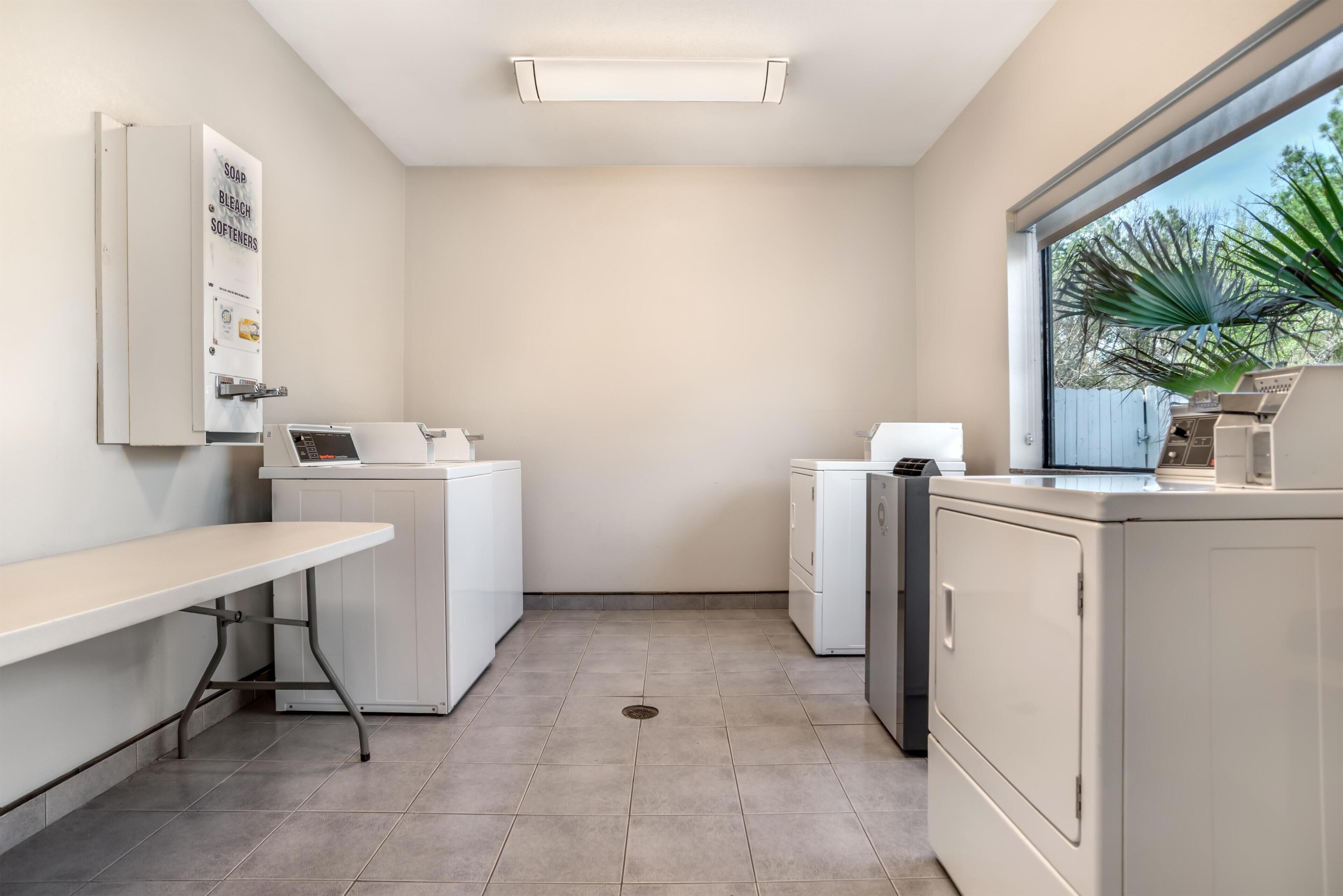 Une buanderie équipée d’un lave-linge, d’un sèche-linge et d’un banc.