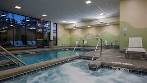 A hot tub with a view of trees outside, a spa timer sign, and a no lifeguard on duty sign.